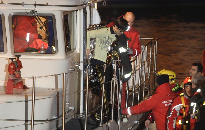 A South Korean man is helped after been rescued with his wife from Costa Concordia cruise as it ran aground off the west coast of Italy at Giglio island
