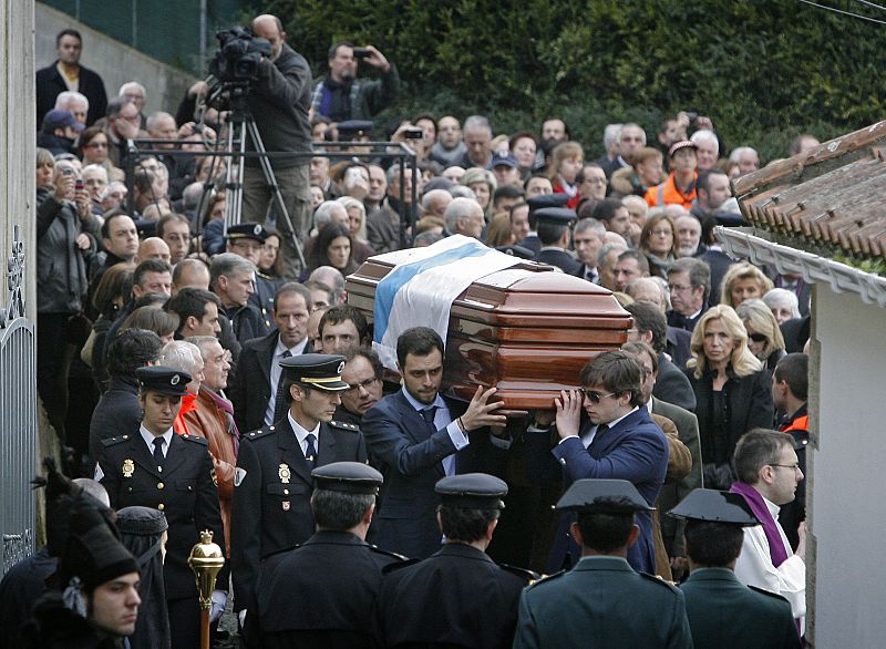 Familiares de Manuel Fraga llevan el féretro cubierto con la bandera de Galicia.