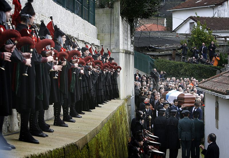 Familiares de Manuel Fraga llevan el féretro cubierto con la bandera de Galicia durante el sepelio celebrado esta tarde en el Parroquia de Perbes.