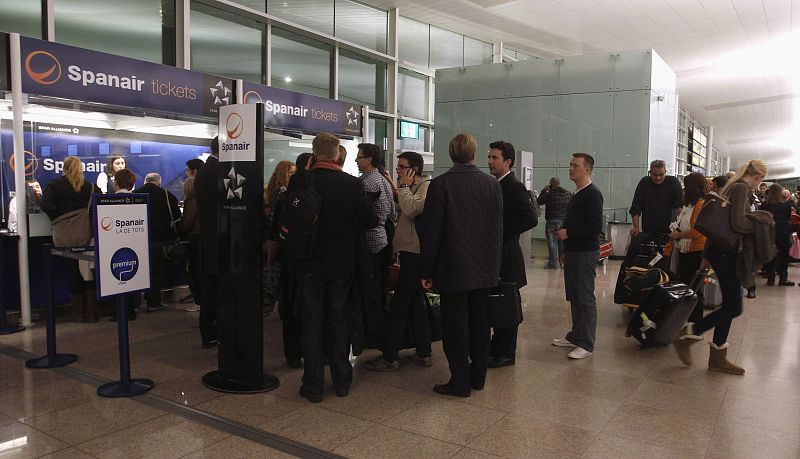 Passengers walk away from the Spanair counter after their flight was cancelled at Barcelona's airport