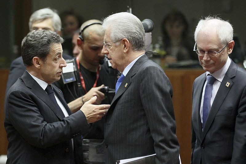 El presidente francés Nicolas Sarkozy (i) conversa con el primer ministro italiano Mario Monti (c) ante la presencia del presidente del Consejo Europeo, Herman Van Rompuy, (d) al comienzo de la cumbre