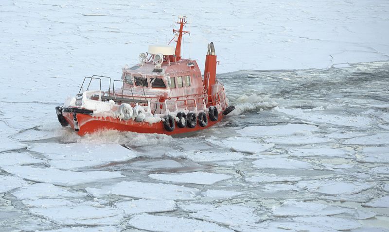 Un barco rompe el hielo en su camino hacia el faro Harmaja en la costa de Helsinki.