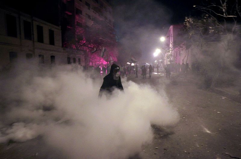 Un manifestante con una máscara de gas entre las granadas lacrimógenas lanzadas por la Policía en El Cairo