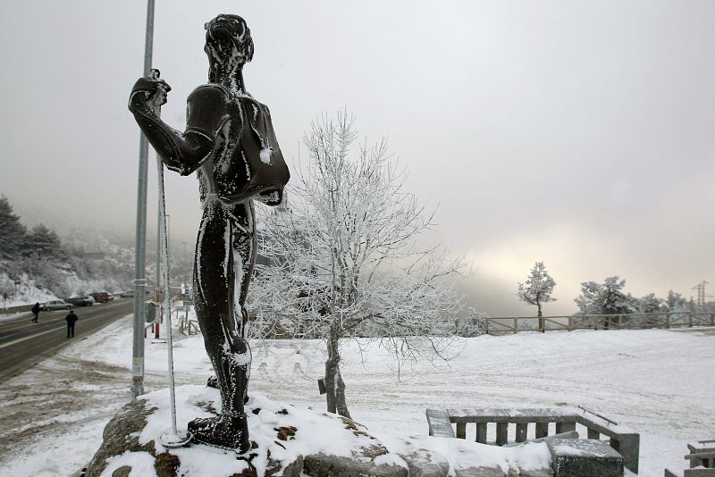 La estatua en honor a los montañeros del Puerto de Navacerrada ha amanecido cubierta de hielo y nieve