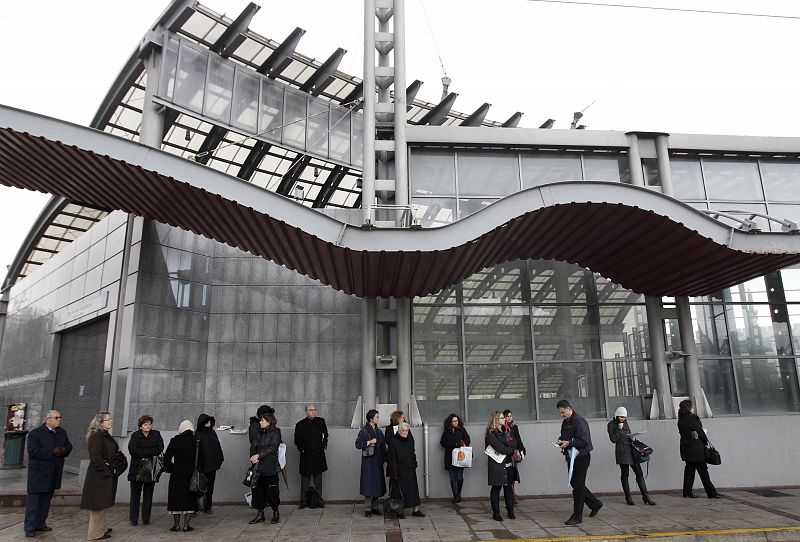 Una fila de personas esperan en una boca de metro de Atenas, cerrado durante las primeras horas del día