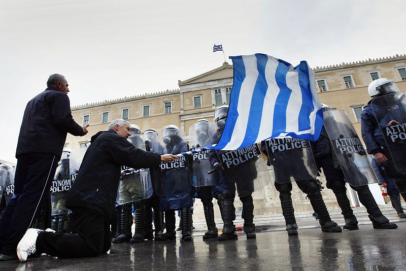 Un grupo de manifestantes, frente a la policía helena en la Plaza Sintagma
