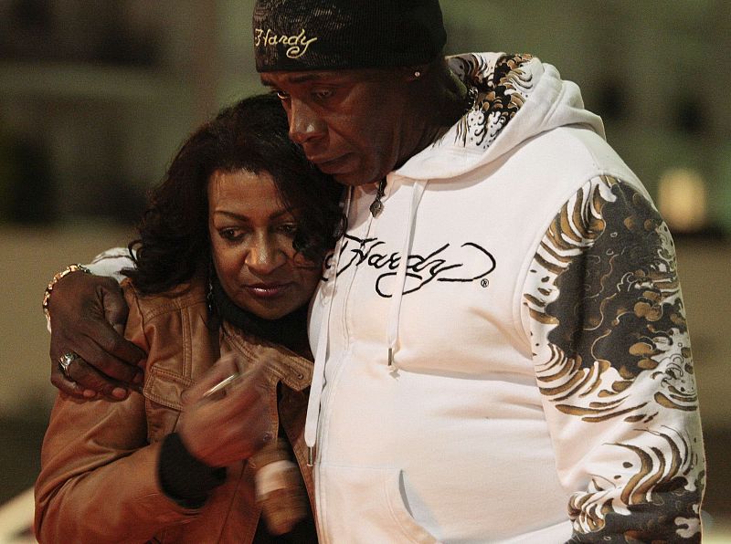 Smith and Malone of Los Angeles embrace as people gather at makeshift memorial on corner of Santa Monica and Wilshire Boulevards to mourn death of singer Whitney Houston in Beverly Hills