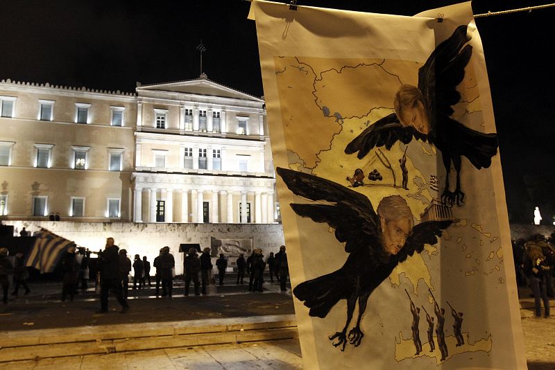 A poster depicting German Chancellor Merkel and the IMF head Lagarde hangs in front of the Greek parliament during an anti-austerity demonstration in Athens' Syntagma square