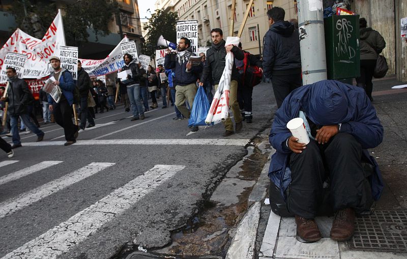 A man begs on a street in athens during a demonstration in Athens