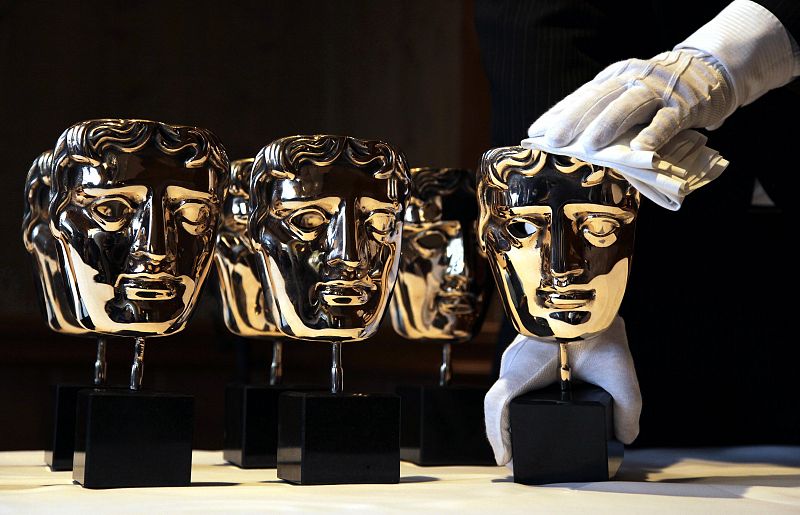 BAFTA award masks are buffed by an employee during a media viewing at the Savoy Hotel in London