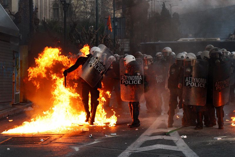 La policía antidisturbios lidia en el terreno contra las bombas incendiarias que lanzan los manifestantes