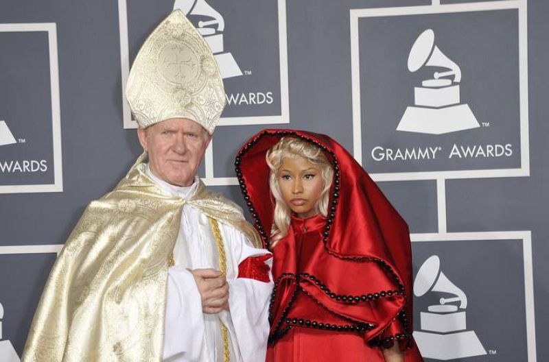 La cantante de 'Hip Hop' Nicki Minaj, con un hábito rojo de monja, llegó acompañada de un hombre disfrazado de papa