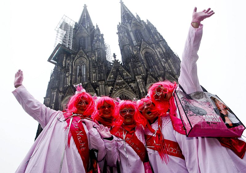 Women dressed for "Weiberfastnaccht" celebrate in front of Cologne's cathedral