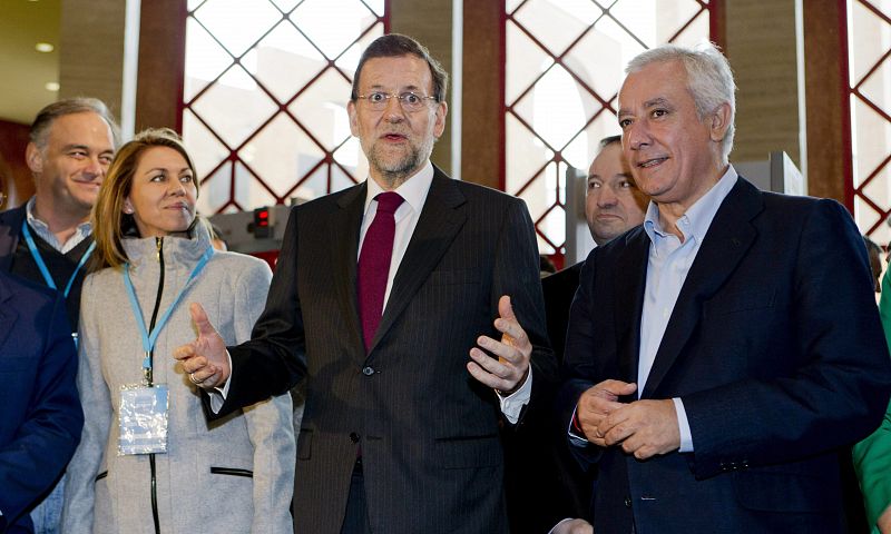 El presidente del Gobierno y del PP, Mariano Rajoy (c), la secretaria general del partido, María Dolores de Cospedal (i), y el líder de los populares andaluces, Javier Arenas (d), a su llegada al Palacio de Congresos de Sevilla.