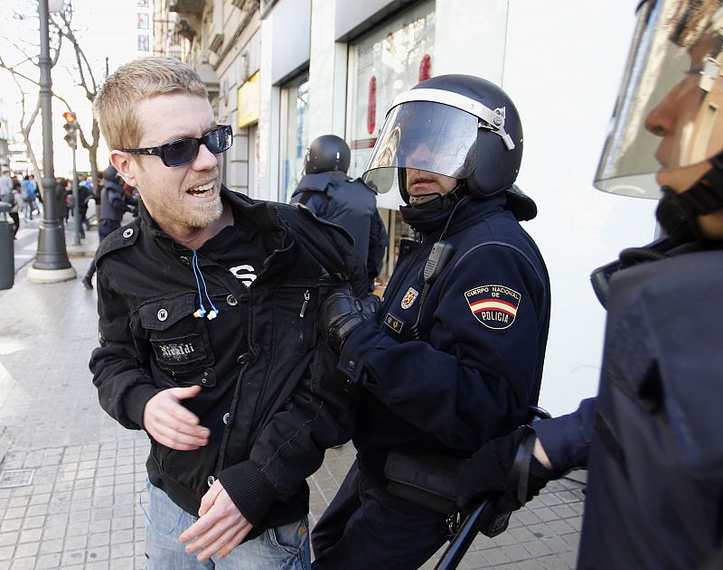 Dos policías sujetan a uno de los manifestantes de Valencia.