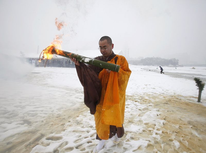 A Buddhist monk carries fire to burn Gomagi prayer sticks in Minamisoma, Fukushima