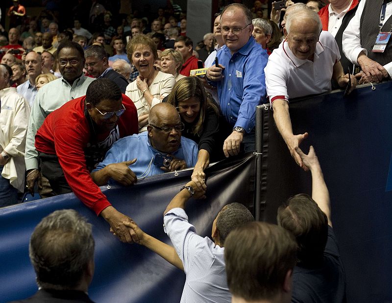 Obama y Cameron aprovechan para saludar a los asistentes al partido en el Dayton Arena.