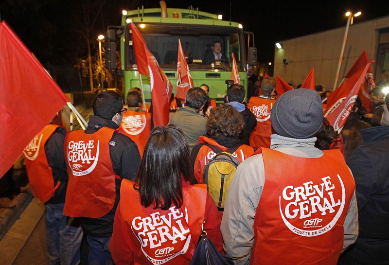 Trabajadores intentan evitar la salida de un camión de la basura en Lisboa durante la huelga general
