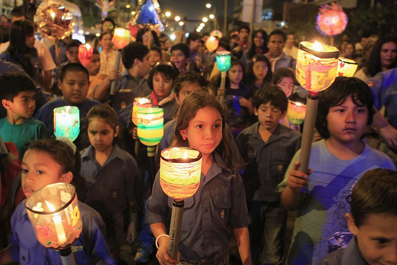Children march while holding candles during Earth Hour in Lima