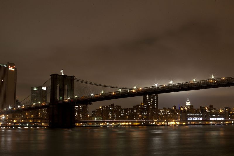 The Brooklyn Bridge is seen with its lights turned off, in participation with Earth Hour, in New York
