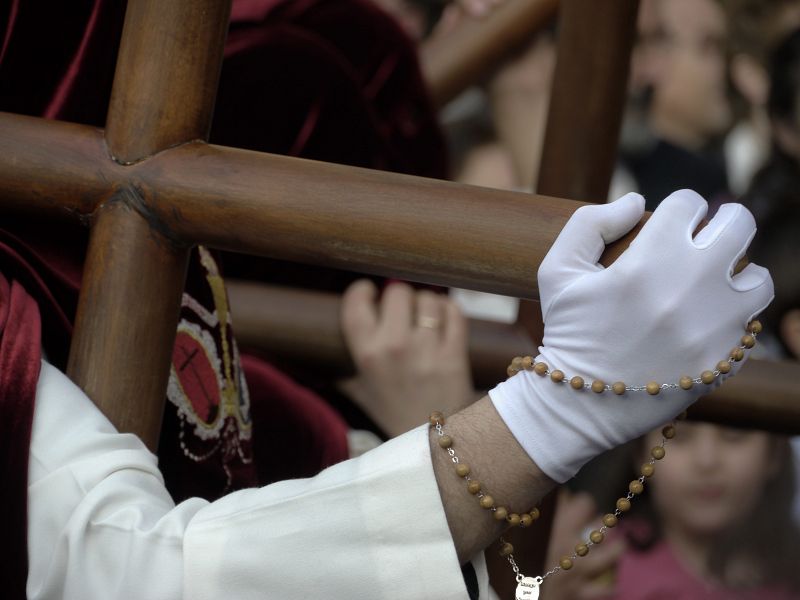 Un penitente porta una Cruz en la procesión de la Santa Cena, en Jaén.