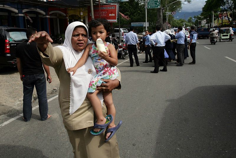 Una mujer intenta parar un coche para huir de la capital de la región, Banda Aceh, tras la alerta