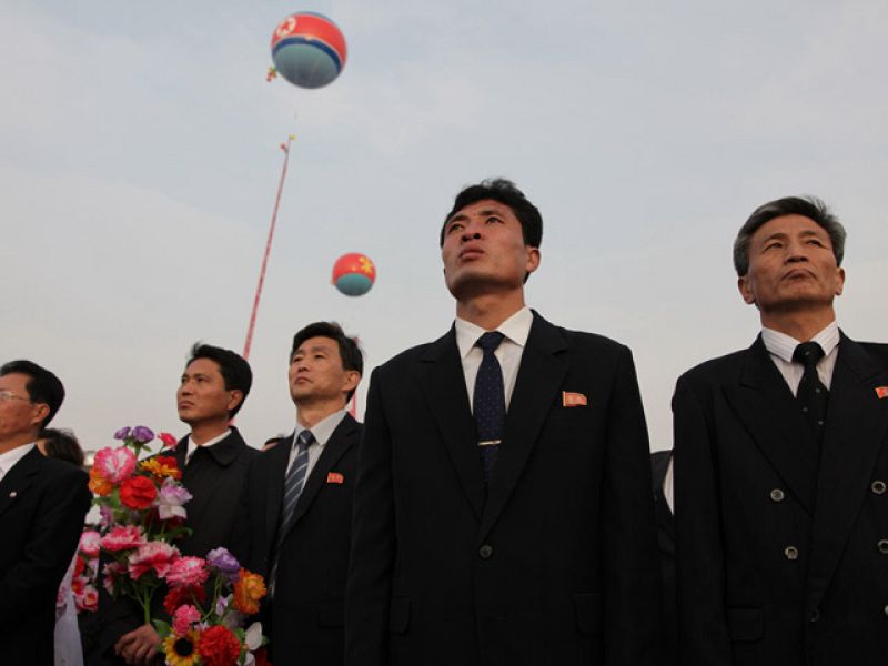Hombres con gesto serio durante la ceremonia.