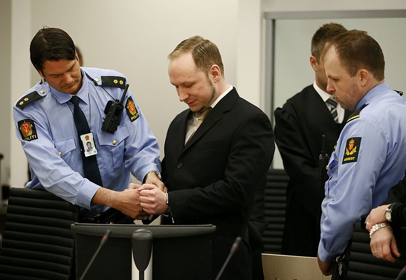 Defendant Norwegian mass killer Breivik has his handcuffs removed after arriving in the courtroom in Oslo
