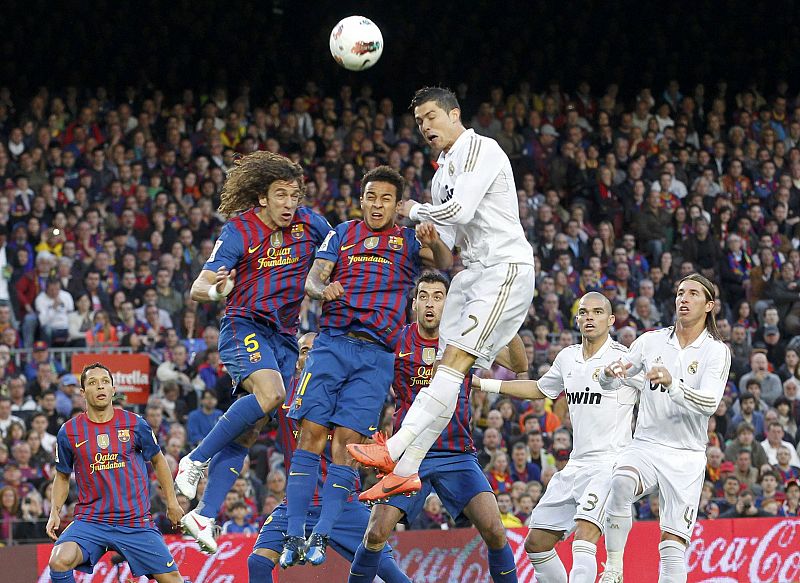 Cristiano Ronaldo remata de cabeza en un córner ante la oposición de Carles Puyol