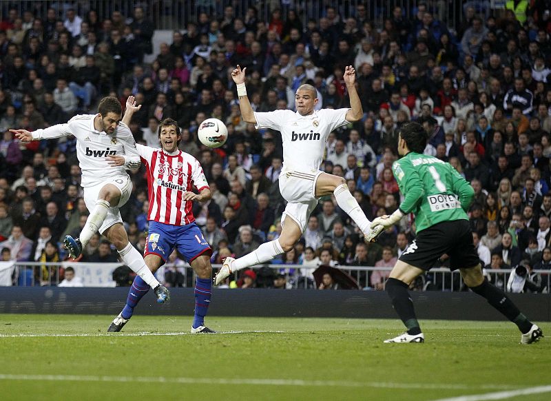 Real Madrid's Higuain scores a goal in front of his teammate  Pepe and Sporting Gijon's Hernandez and goalkeeper Colinas during their Spanish First Division soccer match in Madrid