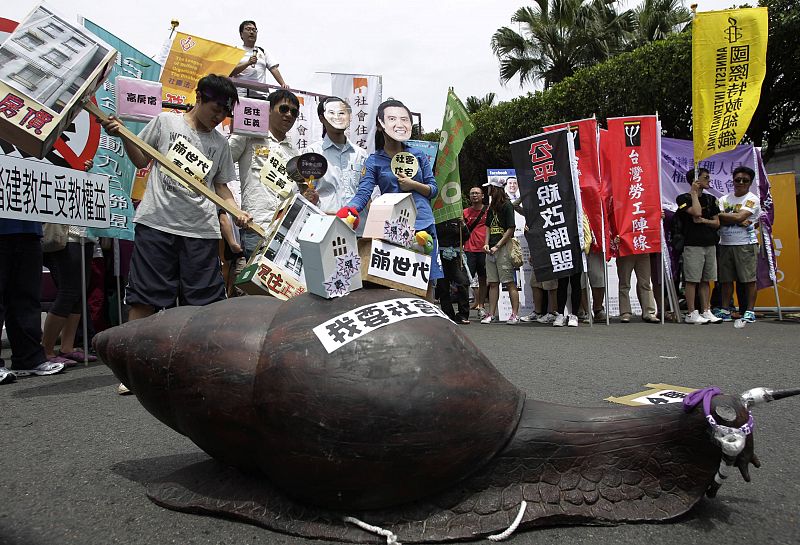 Activistas junto a la escultura de un caracol en la que se puede leer: "Quiero vivienda social", durante la manifestación del 1º de Mayo en Taiwan