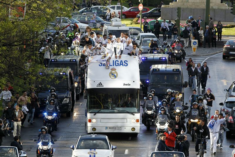 El autobús blanco transita por el madrileño Paseo de la Castellana