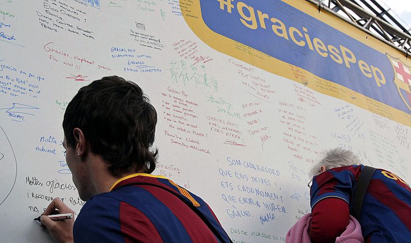 Aficionados de FC Barcelona escriben mensajes de apoyo al técnico culé, Pep Guardiola, en un panel instalado en las inmediaciones del Camp Nou