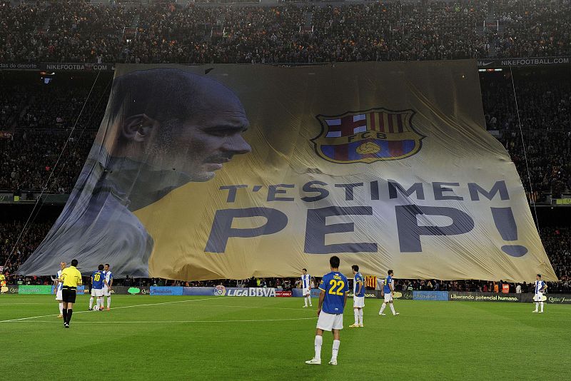 Una pancarta situada en el lateral opuesto a los banquillos recibe a Barça y Espanyol con el mensaje "Te queremos, Pep", en catalán