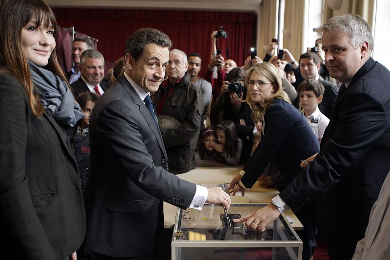 Nicolas Sarkozy, France's President and UMP party candidate for his re-election, votes in the second round of the presidential elections with his wife Carla Bruni-Sarkozy in Paris