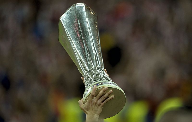 Detalle del trofeo de la Liga Europa en manos de un jugador del Atlético de Madrid.