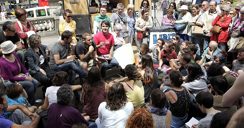 Los "indignados" durante una asamblea en la plaza de Cataluña