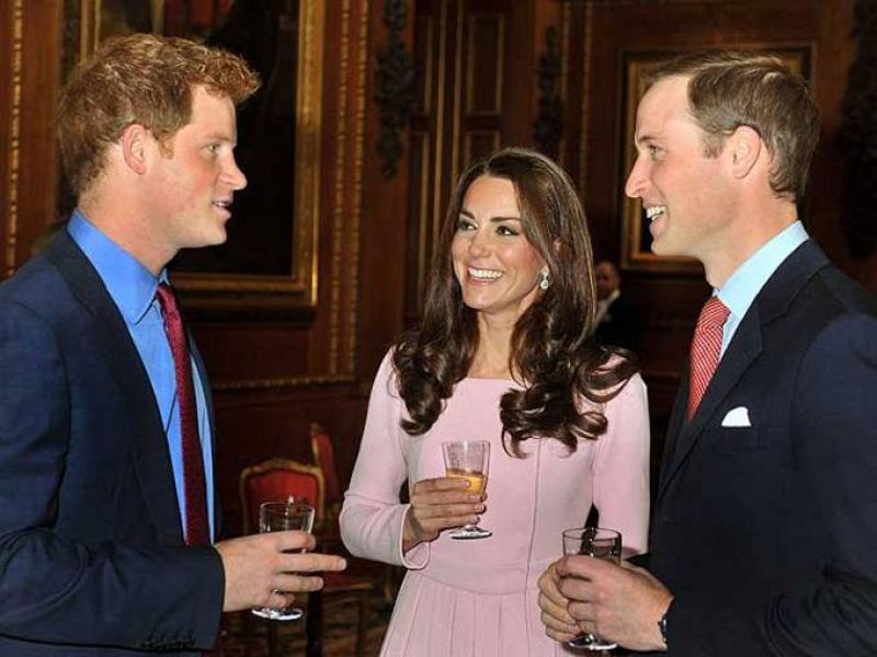 El príncipe Guillermo y su esposa conversan muy animados con el bromista príncipe Enrique.