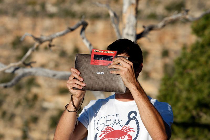 Un aficionado aplica un filtro sobre la cámara de su tableta para fotografiar el eclipse solar