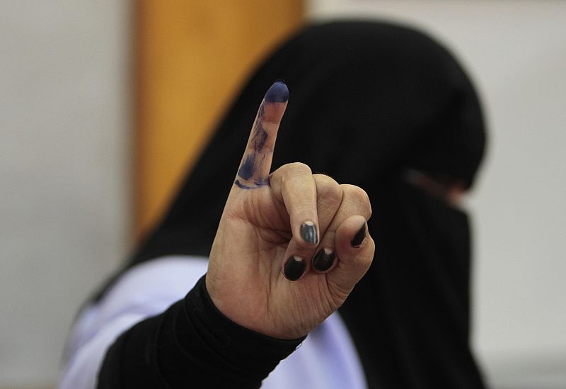 Mujer egipcia muestra su dedo como muestra de su participación en los comicios.