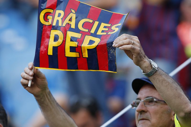 Un aficionado del FC Barcelona sostiene una pancarta de agradecimiento al entrenador del equipo, Josep Guardiola.
