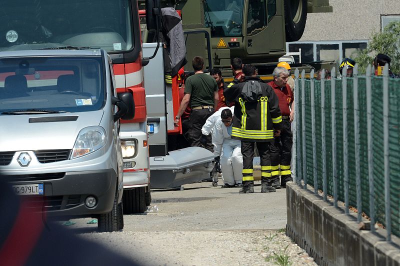 El féretro de uno de los trabajadores fallecidos yace en el suelo de esta fábrica de Medolla