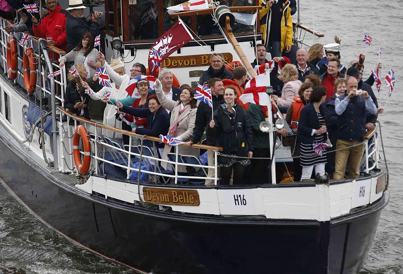 People wave from their boat on the River Thames, in celebration of the Queen's Diamond Jubilee, in London