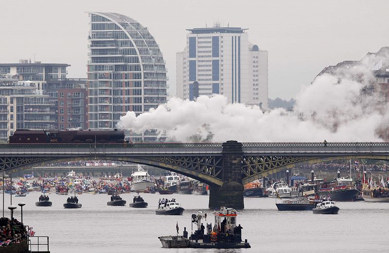 A steam train and pleasure boats from Battersea bridge on the River Thames in London