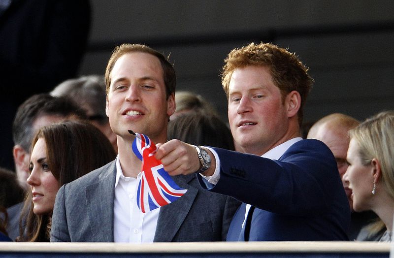 Britain's Prince Harry waves a Union Flag as he watches with Prince William and Catherine, Duchess of Cambridge during the Diamond Jubilee concert in front of Buckingham Palace in London