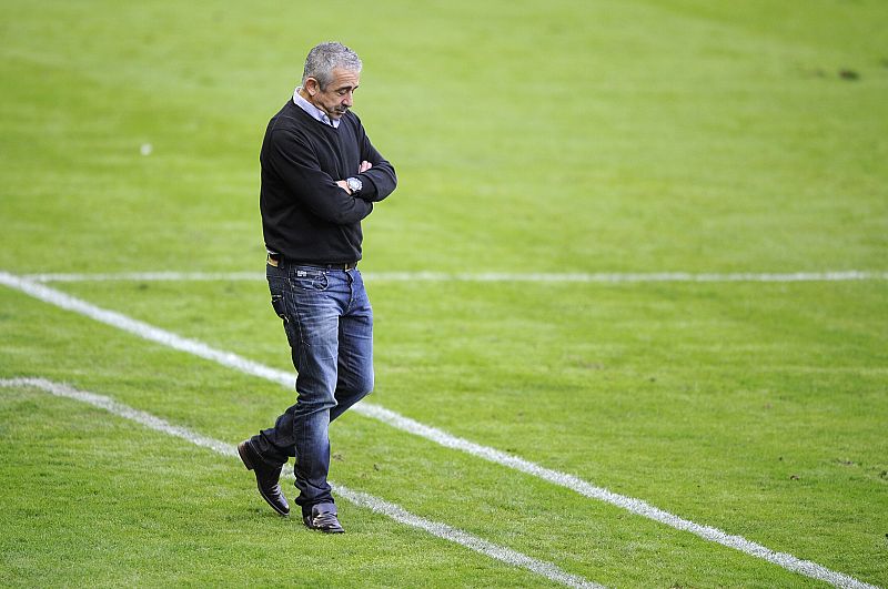 Manuel Preciado pasea solitario por un terreno de juego en una difícil etapa como técnico del Sporting de Gijón.