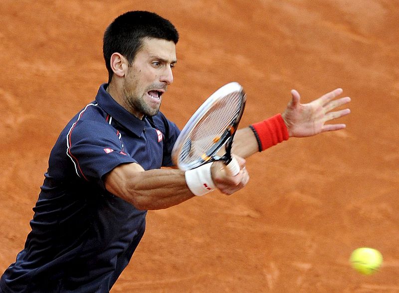 El tenista serbio Novak Djokovic devuelve la bola al español Rafael Nadal.