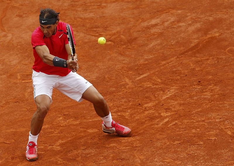 Rafael Nadal devuelve la pelota a Djokovic en la reanudación de la final de Roland Garros 2012.