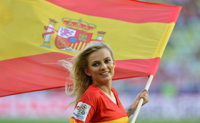 Una cheerleader porta una bandera española