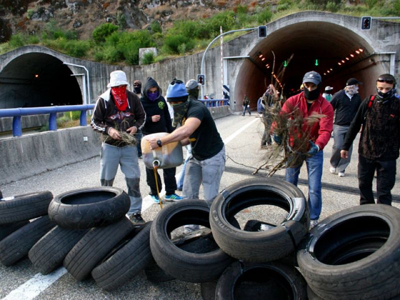 Un grupo de mineros se dispone a quemar neumáticos en la A-6